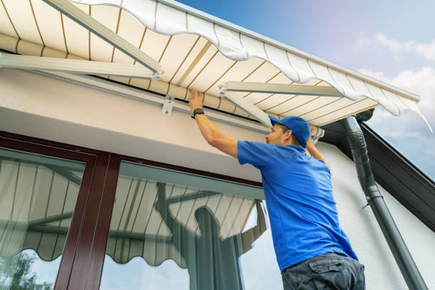 Jasa Kanopi Kain worker install an awning on the house wall over the terrace window