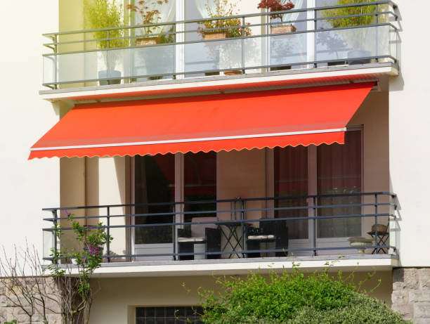 Jasa Kanopi Kain french balcony with awning opened covered by sun shield on a warm summer day