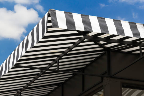 Jasa Kanopi Kain black and white striped awning with blue sky.