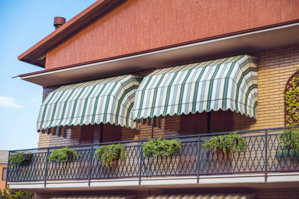 Jasa Kanopi Kain house with balconies with striped awnings